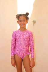 Girls long sleeve surf suit with zip front. Eco-friendly one piece with UPF 50+ sun protection. Designed in Australia for stylish, sun safe swim days.